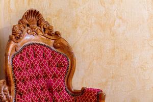 a red chair with a red cushion in a room at Nafsimedon Hotel in Nafplio