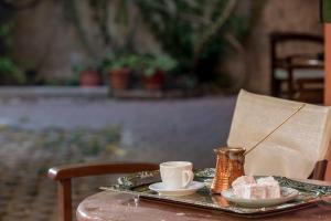 a table with a tray with a cup and a plate of food at Nafsimedon Hotel in Nafplio