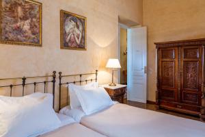 a bedroom with two beds with white sheets and a lamp at Nafsimedon Hotel in Nafplio