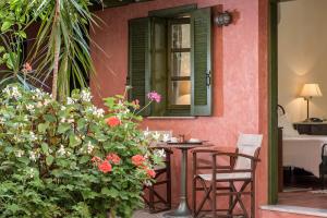 a table and chairs in front of a house with flowers at Nafsimedon Hotel in Nafplio