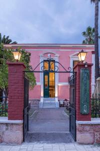 a pink building with a gate in front of it at Nafsimedon Hotel in Nafplio
