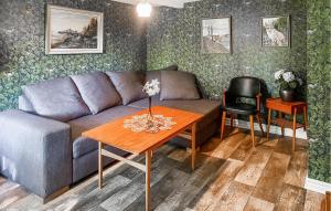 a living room with a couch and a table at Three-Bedroom Holiday Home In Brakne Hoby in Bräkne-Hoby