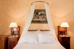 a bed with a canopy in a bedroom with two lamps at Nafsimedon Hotel in Nafplio
