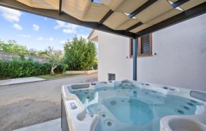 wanna z hydromasażem na podwórku domu w obiekcie Awesome Home In Tinj With Jacuzzi w mieście Tinj