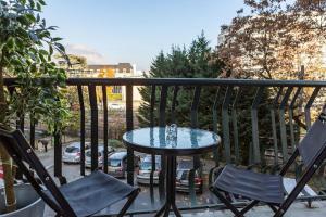 a table and two chairs on a balcony at L'aigle, Bel appartement Proche centre et parking in Grenoble