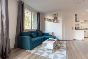 a living room with a blue couch and a table at L'aigle, Bel appartement Proche centre et parking in Grenoble +15 photos