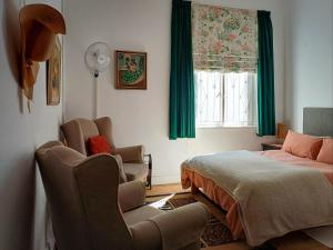 a bedroom with a bed and chairs and a window at 18 on Mark in Willowmore