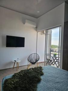 a bedroom with a bed and a television and a chair at Disfruta el encanto llanero in Granada