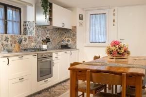 a kitchen with white cabinets and a wooden table at Casa Pina B&B in Spoltore
