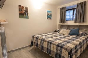 a bedroom with a bed with a plaid blanket at Casa Pina B&B in Spoltore