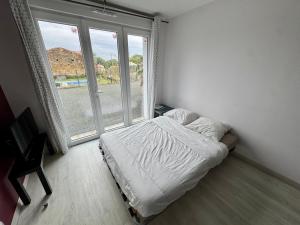 a bedroom with a bed and a large window at Domaine des 5 Roses - Rose Rouge in La Guierche