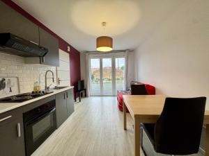 a kitchen with a table and a dining room at Domaine des 5 Roses - Rose Rouge in La Guierche