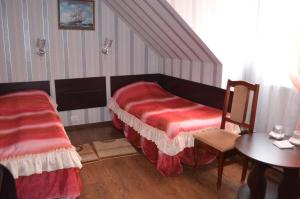 a bedroom with a bed and a table and a chair at Hotel Fiyesta in Starokostyantyniv