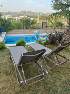 una silla y una mesa junto a una piscina en Isıtmalı Havuzlu Lüks Villa, en Kusadasi 15 fotos más