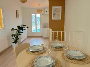 ein Esszimmer mit einem Tisch mit Tellern und Weingläsern in der Unterkunft "Casa Mia" - Sea View - Old Town House - 4 persons in Menton