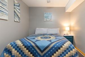a bedroom with a bed with a blue and white quilt at Artilla Cove Cabin 8- Lakeview- BBQ Area- Pool in Branson +24 photos