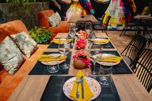 a long wooden table with yellow napkins and glasses at Nilka Hotel Boutique in Santa Bárbara de Samaná