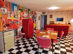 a vintage kitchen with a woman and a refrigerator at LE VEGAS Logis de luxe avec salle de jeux in Champagnole