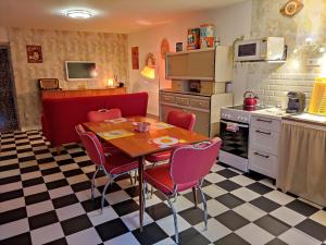 a kitchen with a table and chairs in a kitchen at LE VEGAS Logis de luxe avec salle de jeux in Champagnole +45 photos