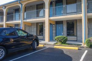 a black car parked in a parking lot in front of a building at Grand Vista Hotel in Huntsville