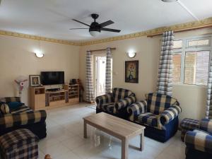 a living room with couches and a tv at 3-Bedroom Duplex, Residence Bayview, Flic-en-Flac in Flic-en-Flac