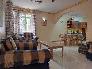 a living room with two couches and a table at 3-Bedroom Duplex, Residence Bayview, Flic-en-Flac in Flic-en-Flac