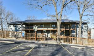 a large house with a fence in front of it at Divine 9 Condo -Fishing Lake & Hiking Trails in Reeds Spring