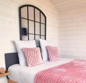 a bedroom with a bed with pink pillows at La Bayeuzen - La Mer in Saint-Côme-de-Fresné