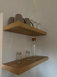 a wooden shelf with glasses and bottles on it at Rheydt Comfort Stay Apartment in Mönchengladbach +6 photos