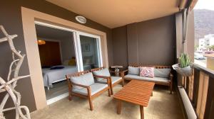 バジェ・グラン・レイにあるApartamento La Olaのバルコニー(ベッド1台、テーブル、椅子付)が備わる客室です。