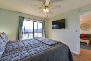 a bedroom with a bed with a ceiling fan and a window at Mountain Getaway- Outdoor Pool Hiking Trails in Reeds Spring +24 photos