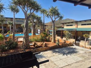 a park with palm trees and a swimming pool at Jakkalswater guest farm in Nababeep