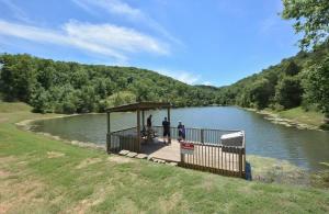 a group of people standing on a dock next to a river at Westcreek Ranch - No Stairs in Branson West