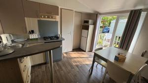 a kitchen with a counter and a table in a room at Mobil Home Ohana Camping du Ried in Boofzheim