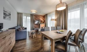 a dining room and living room with a table and chairs at AlpenParks Hotel & Apartment Central Zell am See in Zell am See