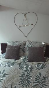 a heart sign above a bed with two pillows at PETIT PARADIS in La Bruffière
