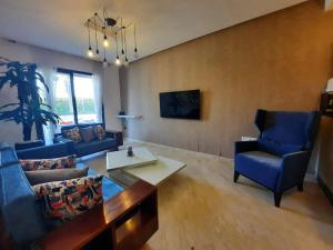 阿加迪尔Superbe appartement Résidence Hivernage Founty Agadir的客厅里有蓝色的沙发和一张桌子