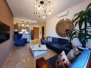 阿加迪尔Superbe appartement Résidence Hivernage Founty Agadir的客厅里有一张蓝色的沙发和一张桌子
