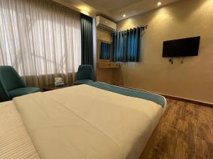 a room with a bed and a flat screen tv at Gabry Grand Egyptian Museum and Pyramids Hotel in Cairo