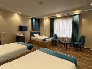 a hotel room with two beds and a tv at Gabry Grand Egyptian Museum and Pyramids Hotel in Cairo