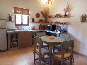a kitchen with a table and chairs and a kitchen with a refrigerator at Casa Inkill Huasi in Tilcara