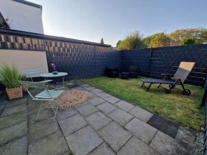 un patio trasero con una mesa y sillas y una valla en Gästehaus in Köln Rath-Heumar, en Colonia