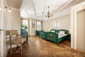 1 dormitorio con camas verdes y techo blanco en Hotel Chesa Spuondas, en St. Moritz