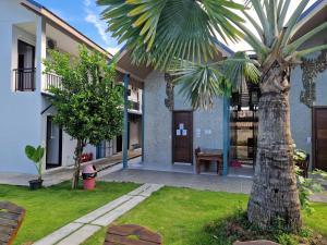 a palm tree in a yard next to a building at Atlas Central in Pai