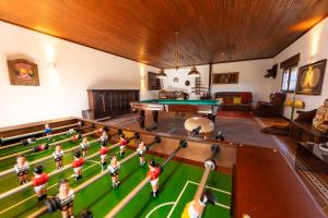 a group of children playing table tennis in a living room at Alentejo Villa Nordic Spa & Pool in Santo António do Alcôrrego