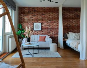 salon z białą kanapą i ceglaną ścianą w obiekcie 7th Floor Apartment Mokotów w Warszawie
