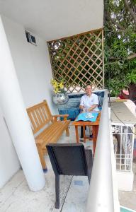 a man sitting at a table in a patio at Hotel Tranvia in Santa Marta