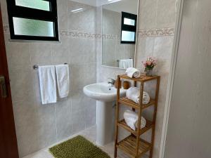 ein Badezimmer mit Waschbecken, Spiegel und Handtüchern in der Unterkunft Refúgio dos Prazeres - Madeira Inn Group in Prazeres + 21 Fotos