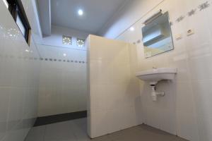 a bathroom with a sink and a mirror at De Dukuh Guest House in Kuta