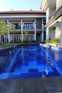 a swimming pool in front of a building at De Dukuh Guest House in Kuta +13 photos